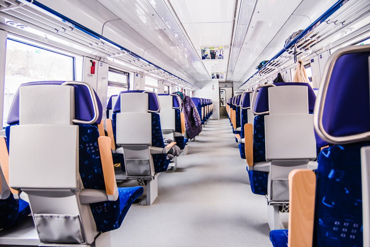 Leerer Fahrgastraum eines modernen Zuges mit Sitzreihen und Mittelgang